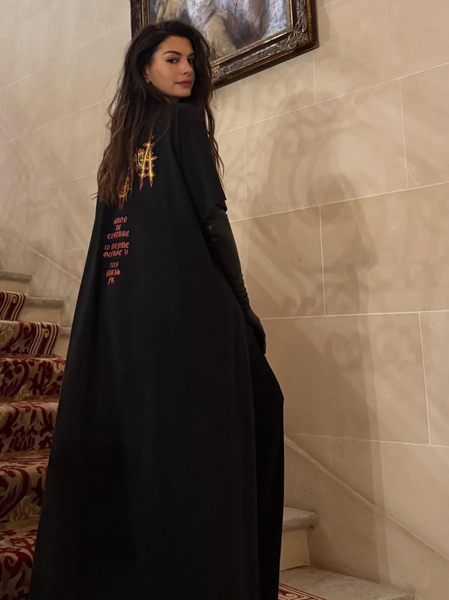 Gaya ini memberi kesan teatrikal yang tetap sleek, khas Balenciaga. Kaus kustom tersebut terinspirasi dari salah satu look di runway koleksi Spring 2026. Foto: Instagram/@annehathaway