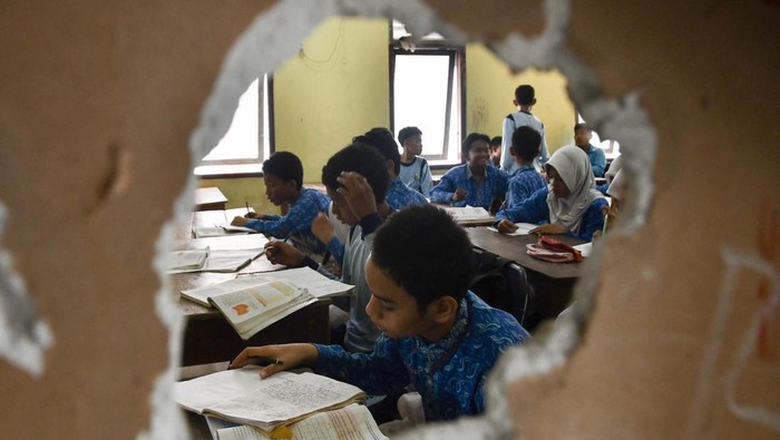 Bangunan SMPN 62 Bekasi Rusak, Tiga Siswa Satu Meja untuk Belajar Tiga orang siswa menggunakan satu meja belajar di Unit Sekolah Baru (USB) SMP 62 Medan Satria, Bekasi, Jawa Barat, Kamis (9/10/2025). Menurut pihak Sekolah sebanyak 320 siswa menggunakan hanya empat ruang kelas yang layak digunakan karena sudah tiga tahun bangunan lainnya rusak. ANTARA FOTO/Fakhri Hermansyah/