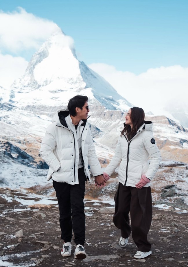 Setelah membagikan momen lamaran romantis, Syifa dan El kembali memamerkan foto-foto mereka saat berlibur di Swiss. Di salah satu momen terlihat keduanya yang bergaya couple mengenakan jaket musim dingin yang sama. Foto: Instagram/@elelrumi/@syifahadju