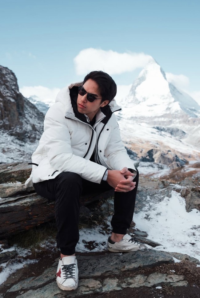 El tampak memadukan jaket padding putihnya dengan celana hitam panjang. Ia juga melengkapi penampilannya dengan kaca mata hitam. Foto: Instagram/@elelrumi/@syifahadju