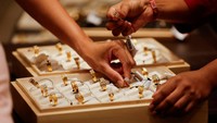 Seorang pegawai menunjukkan cincin emas kepada pelanggan di sebuah toko perhiasan di Ahmedabad, India, Rabu (8/10/2025). Rekor baru ini menegaskan posisi emas sebagai aset aman di tengah ketidakpastian ekonomi global. REUTERS/Amit Dave  