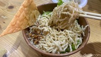 Tim detikFood sempat mencicipi Cwie Mie Malang Orens seharga Rp 35.000 per porsi. Teksturnya mirip mie ayam dengan rasa gurih dari bumbu kecap asin. Topping-nya terdiri dari ayam serbuk, selada, dan pangsit goreng renyah. Foto: Yenny Mustika Sari/detikcom