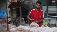 Suasana serupa terlihat di toko-toko kecil. Seorang penjual roti di Khan Younis mulai mengemasi dagangannya sambil berharap situasi segera pulih. REUTERS/Ramadan Abed