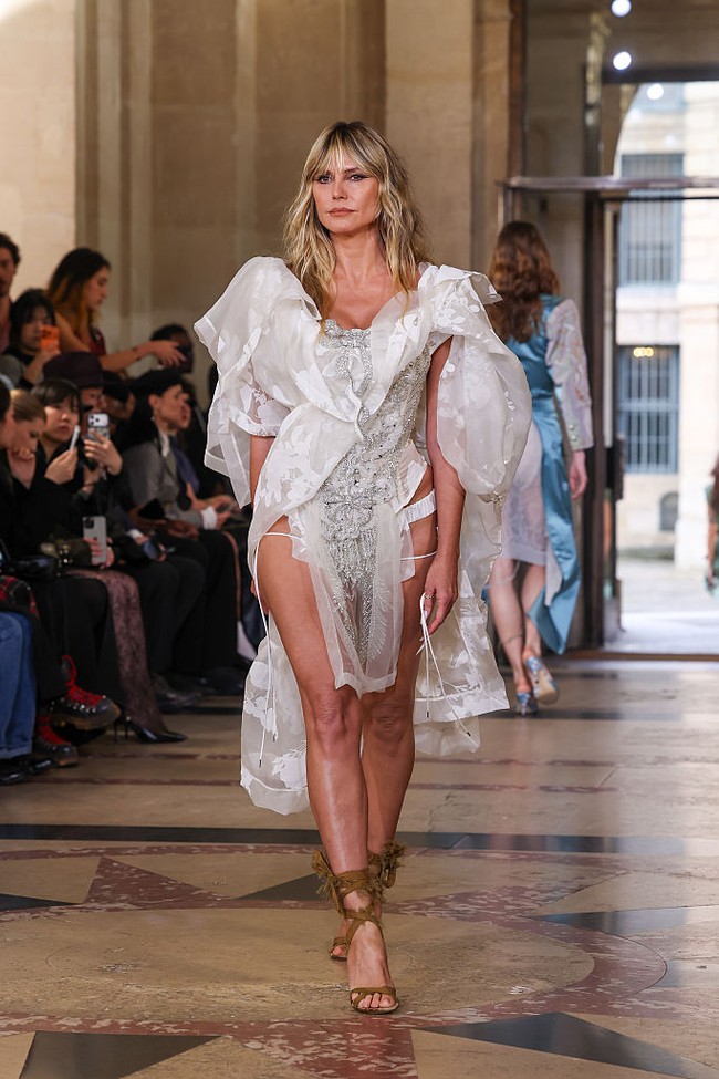 Bagian bodice korsetnya dihiasi ornamen filigree perak lengkap dengan pita bertabur permata di garis leher yang rendah, serta detail kain tipis berhiaskan kristal berbentuk bulu di bagian depan. Foto: Getty Images/Peter White