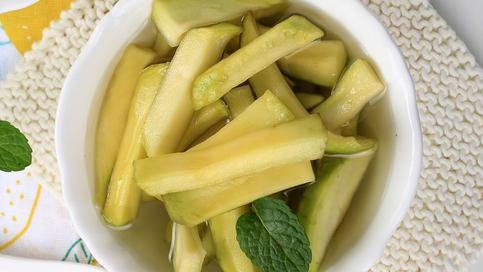 Top View Homemade Manisan or Asinan Mangga is Candied Young Mango Pickles, Thin Sliced Mix with Water and Sugar