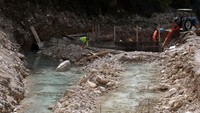 Pekerja lokal mengeruk kerikil dari dasar sungai untuk bahan beton, praktik yang menurut ahli merusak aliran alami dan membuat tepi sungai tidak stabil. Foto: REUTERS/Florion Goga
