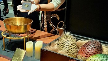 Di sisi kanan ada koper berisikan 3 telur naga, lalu di kiri tampak Realme 15 Pro Game of Thrones Limited Edition di atas sejenis panci penampang. Mau ngapain, sih, nih? Foto: Kris Fathoni/detikINET