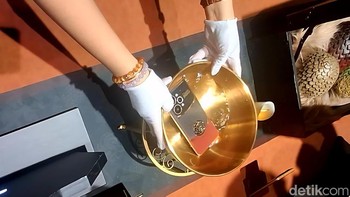 Nah, rupanya ini adalah demonstrasi Realme 15 Pro Game of Thrones Limited Edition yang bisa berubah warna. Dari hitam, lapisan kulit di belakang HP ini akan menjadi merah saat dipanaskan dalam suhu 44 derajat Celcius. Foto: Kris Fathoni/detikINET