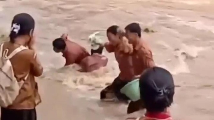 Sejumlah siswa menyeberangi sungai yang banjir di Kabupaten Nias Selatan. (Tangkapan layar media sosial)