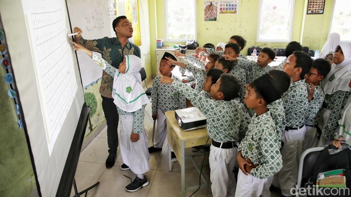 Sejumlah siswa-siswi belajar bahasa arab dengan sistem digital dan membaca buku dari perpustakaan digital di kawasan Madrasah Ibtidaiyah Negeri 20, Rorotan, Jakarta Utara, Kamis (9/10/2025)