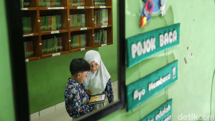 Sejumlah siswa-siswi belajar bahasa arab dengan sistem digital dan membaca buku dari perpustakaan digital di kawasan Madrasah Ibtidaiyah Negeri 20, Rorotan, Jakarta Utara, Kamis (9/10/2025)