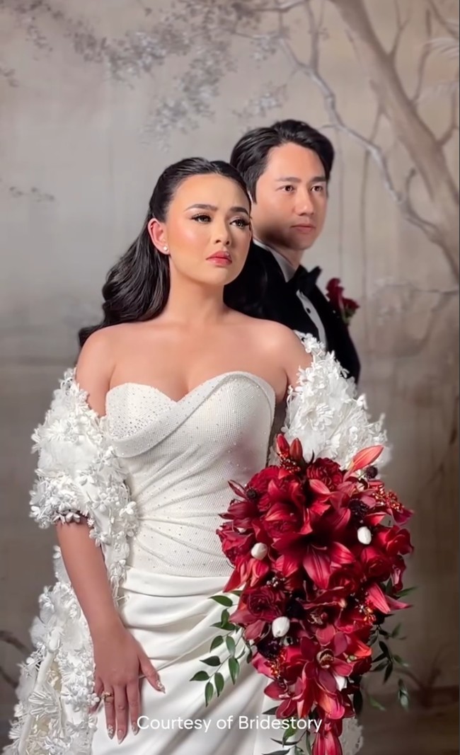 Amanda tampil anggun dalam gaun putih strapless rancangan Hian Tjen. Gaun tersebut memiliki potongan sweetheart neckline. Desainnya menonjolkan lekuk tubuh dengan balutan bahan satin berkilau. Foto: Instagram/@thebridestory