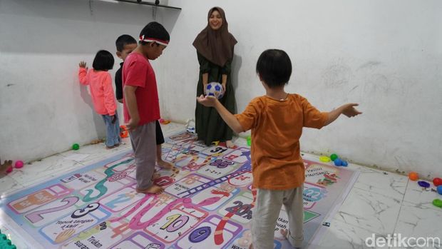 Guru dan anak berkebutuhan khusus di Yayasan Bina Insani bermain bola dan bernyanyi sebelum belajar dan terapi Diet Elektronik dilakukan