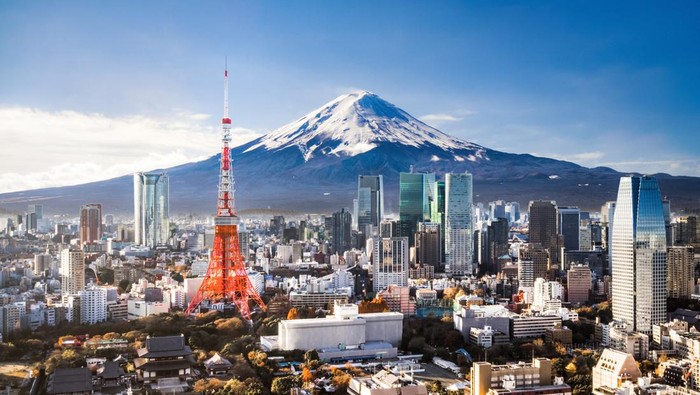 Aerial view of Mt. Fuji, Tokyo Tower and modern skyscrapers in Tokyo on a sunny day.