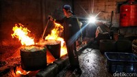 Pekerja merebus kerang hijau di atas tungku kayu besar. Perebusan berlangsung 10–15 menit untuk membuka cangkang dan memudahkan proses pengupasan.
