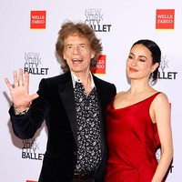 Sementara itu, Melanie Hamrick tampil anggun dalam gaun satin merah rancangan The Danes New York dengan potongan leher rendah dan belahan tinggi di bagian paha. Sebagai mantan penari balet profesional. Rambutnya ditata rapi dalam gaya slicked-back bun, dilengkapi dengan anting panjang perak, sepatu Aquazzura, dan cincin pertunangan di jarinya. Ia memilih riasan natural dengan bibir warna nude. Foto: Variety via Getty Images/Stephanie Augello