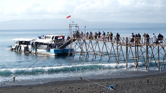 Pekerja memindahkan berbagai barang ke dalam perahu tradisional di Pelabuhan Tribuana, Desa Kusamba, Klungkung, Bali, Jumat (10/10/2025). Perahu yang dapat mengangkut beban 15 ton tersebut merupakan alat transportasi laut tradisional yang digunakan oleh warga untuk sehari-hari mengirim logistik ke kawasan wisata di Pulau Nusa Penida. ANTARA FOTO/Nyoman Hendra Wibowo