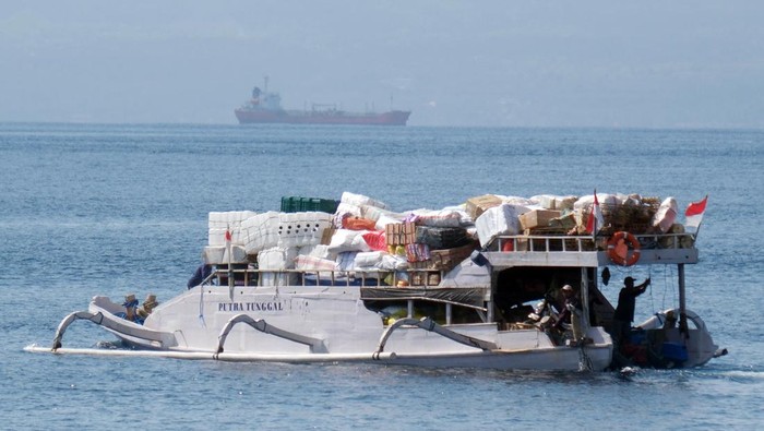 Pekerja memindahkan berbagai barang ke dalam perahu tradisional di Pelabuhan Tribuana, Desa Kusamba, Klungkung, Bali, Jumat (10/10/2025). Perahu yang dapat mengangkut beban 15 ton tersebut merupakan alat transportasi laut tradisional yang digunakan oleh warga untuk sehari-hari mengirim logistik ke kawasan wisata di Pulau Nusa Penida. ANTARA FOTO/Nyoman Hendra Wibowo