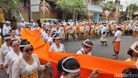 Terlihat ribuan krama Bali keluar dengan menggunakan pakaian adat dan membawa aneka banten, senjata nawa sanga, panca dewata, baleganjur, tambur, seserahan hasil bumi, hewan (bebek), hingga membentangkan kain warna orange sepanjang kurang lebih 15 meter. (Ahmad Firizqi/detikBali).