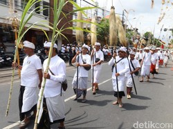 Iring-iringan pemedek dalam ritual Nyenuk membawa tombak, umbul-umbul, dan gamelan baleganjur berangkat dari Puri Agung Jro Kuta berada di barisan paling depan, Sabtu (11/10/2025). (Aryo Mahendro/detikBali).