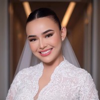 Arnold Dominggus menata rambut Amanda dengan gaya sanggul rendah berbelah tengah yang sleek dan rapi. Look ini menonjolkan fitur wajahnya yang tegas sekaligus mempertegas kesan anggun dalam balutan gaun lace putihnya. Foto: Instagram/@bennusorumba
