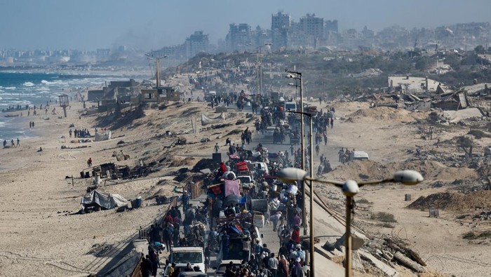 Palestinians walk among rubble following Israeli forces withdrawal from the area, amid a ceasefire between Israel and Hamas in Gaza, in Gaza City October 11, 2025. REUTERS/Ebrahim Hajjaj