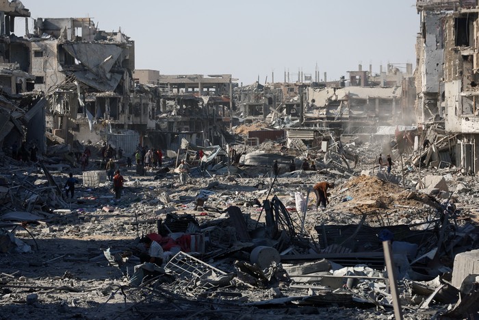 Palestinians walk among rubble following Israeli forces withdrawal from the area, amid a ceasefire between Israel and Hamas in Gaza, in Gaza City October 11, 2025. REUTERS/Ebrahim Hajjaj