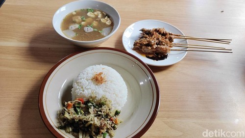 Paket komplet nasi lawar daging sapi plus soto sapi dan sate sapi bumbu kacang di Warung Dek Soto, Desa Darmasaba, Kecamatan Abiansemal, Badung, Bali. (Foto: Agus Eka/detikBali)
