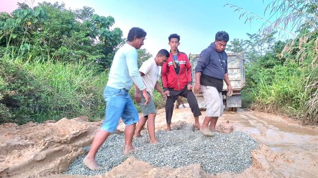 Truk pengangkut bahan material terjebak di lumpur jalan Kapuak - Seputuk, jalan diperbaiki mandiri. (Oktavian Balang/detikKalimantan)