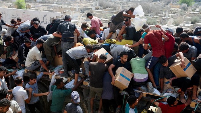 Palestinians carry aid supplies that entered Gaza, amid a ceasefire between Israel and Hamas, in Khan Younis, in the southern Gaza Strip October 11, 2025. REUTERS/Ramadan Abed     TPX IMAGES OF THE DAY