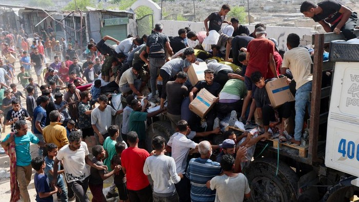 Palestinians carry aid supplies that entered Gaza, amid a ceasefire between Israel and Hamas, in Khan Younis, in the southern Gaza Strip October 11, 2025. REUTERS/Ramadan Abed     TPX IMAGES OF THE DAY