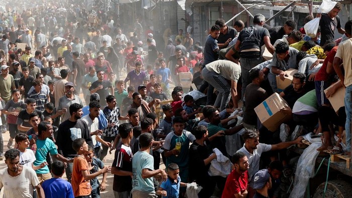 Palestinians carry aid supplies that entered Gaza, amid a ceasefire between Israel and Hamas, in Khan Younis, in the southern Gaza Strip October 11, 2025. REUTERS/Ramadan Abed     TPX IMAGES OF THE DAY