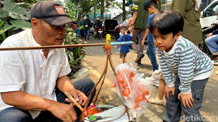 Danu, penjual permen gulali saat melayani pembeli.