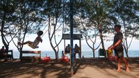 Wisatawan bermain ayunan di tepi Pantai Pulau Santen, Banyuwangi, Jawa Timur, Minggu (12/10/2025). Foto: ANTARA FOTO/Budi Candra Setya