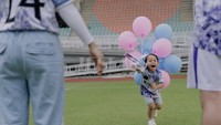 Abang L berlari membawa balon berwarna biru muda dan pink. Foto: Instagram @lestikejora