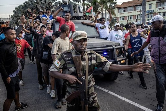 Members of a section of the Malagasy army ride an armoured vehicle surrounded by protesters celebrating their arrival as they head to City Hall to address the population after securing the area following clashes between demonstrators and security forces during protests calling for the resignation of President Andry Rajoelina in Antananarivo, on October 11, 2025. Groups of Madagascar soldiers joined thousands of protestors in the capital on October 11, 2025, after announcing they would refuse any orders to shoot demonstrators.
Fresh youth-led demonstrations in Antananarivo drew large crowds in one of the biggest gatherings since a protest movement erupted on the Indian Ocean island on September 25.
After police used stun grenades and tear gas to try to disperse the demonstrators, soldiers arrived at the heart of the gathering near the Lake Anosy area where they were welcomed with cheers. (Photo by Luis TATO / AFP)