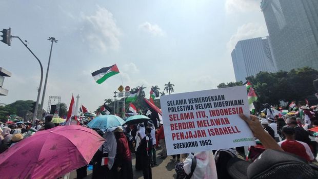 Massa membawa bendera Palestina berukuran besar saat demo (Taufiq/detikcom)