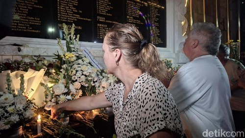 Masyarakat dan turis meletakkan bunga, lilin, dan berdoa untuk memperingati peristiwa 23 tahun tragedi Bom Bali, Minggu (12/10/2025)