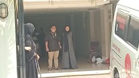 Olla Ramlan memakai hijab dan gamis hitam berdiri di depan rumah duka tempat ibunda, Tisah Djahri disemayamkan yang berada di kawasan Pondok Indah, Jakarta Selatan, Minggu (12/10/2025). Foto: Muhammad Ahsan Nurrijal/detikcom