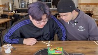 Mereka juga diminta mencicipi Indomie Soto Mie. Varian mie instan rebus yang diduga mirip pho Vietnam oleh 2 pria Korea ini. Foto: YouTube Koreander