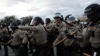 Dalam foto yang terekam di lokasi kejadian, tampak petugas kepolisian lengkap dengan perlengkapan anti huru-hara berusaha membubarkan demonstran. Foto: REUTERS/Jeenah Moon
