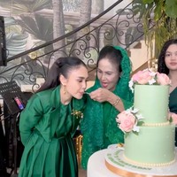 Yuni Shara memilih gaya yang lebih formal dengan long dress berpotongan trench coat dan detail ikat pinggang. Sentuhan bros emas di dada menambah kesan berkelas sekaligus mempercantik tampilannya. Foto: Instagram/@krisdayantilemos