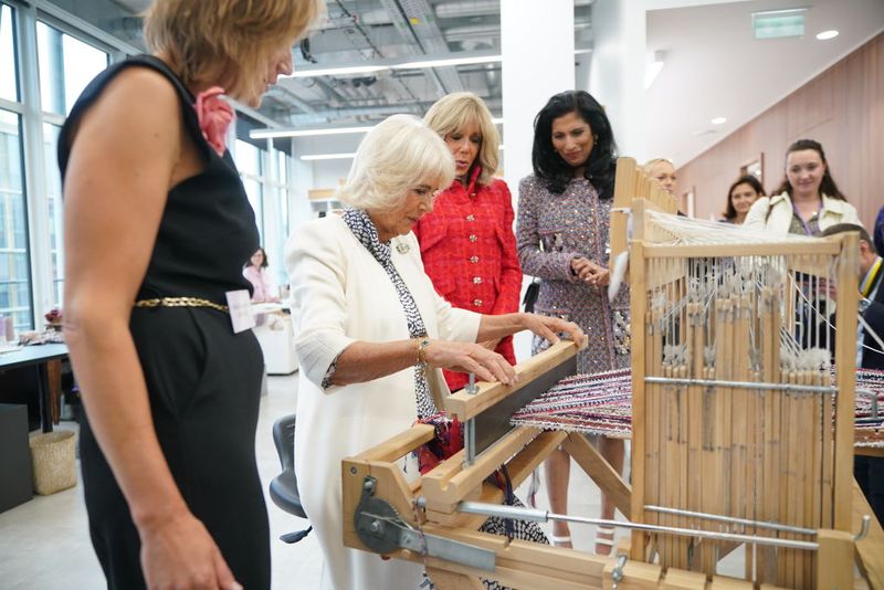 Berkunjung ke Pusat Artisan Chanel di Le 19M Paris PARIS, FRANCE - SEPTEMBER 21: Queen Camilla, watched by Brigitte Macron (second right), and Global Chief Executive officer of Chanel, Leena Nair (right), tries her hand at weaving tweed on a traditional loom in the Maison Lesage, during her visit to la Galerie du 19M in Paris, on day two of the state visit to France on September 21, 2023 in Paris, France. Britain's King Charles III and his wife Queen Camilla are on a three-day state visit starting on September 20, 2023, to Paris and Bordeaux, six months after rioting and strikes forced the last-minute postponement of his first state visit as king. (Photo by Yui Mok - Pool/Getty Images)
