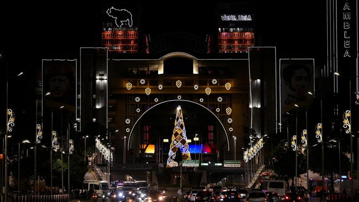 People pose with Christmas decorations in a public square as the holiday season officially begins since  Venezuela's President Nicolas Maduro announced that Christmas celebrations would start in October, two months ahead of the traditional season, in Caracas, Venezuela October 1, 2025. REUTERS/Gaby Oraa