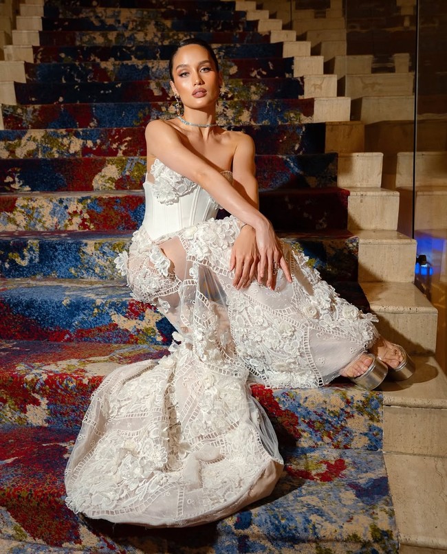 Panel transparan di bagian kaki berpadu dengan potongan high slit dan bordiran floral rumit, menciptakan kesan feminin sekaligus bold khas gaya Cinta Laura. Foto: Instagram/@claurakiehl