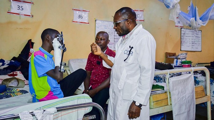 Samson Muhindo Kalumbi from the International Committee of the Red Cross (ICRC) attends to Asende Obato, 16, who was injured on his arm by an explosive device while playing, at the Beni General Hospital in Beni, North Kivu Province of the Democratic Republic of Congo October 2, 2025. REUTERS/Gradel Muyisa Mumbere