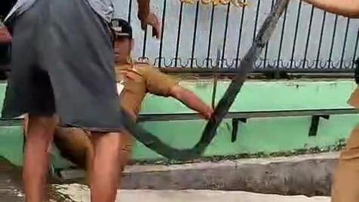 Lurah Perintis Muhammad Fadli terjatuh ke parit karena didorong warga saat bongkar polisi tidur. (Dok. Kecamatan Medan Timur)