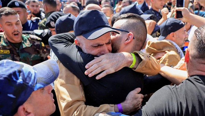 Seorang tahanan Palestina yang dibebaskan memeluk keluarganya setelah dibebaskan dari penjara Israel sebagai bagian dari pertukaran sandera-tahanan dan kesepakatan gencatan senjata di Gaza antara Hamas dan Israel, di Ramallah, Tepi Barat yang diduduki Israel, 13 Oktober 2025. REUTERS/Mussa Qawasma