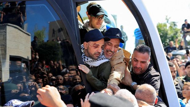 Seorang tahanan Palestina yang dibebaskan memeluk keluarganya setelah dibebaskan dari penjara Israel sebagai bagian dari pertukaran sandera-tahanan dan kesepakatan gencatan senjata di Gaza antara Hamas dan Israel, di Ramallah, Tepi Barat yang diduduki Israel, 13 Oktober 2025. REUTERS/Mussa Qawasma