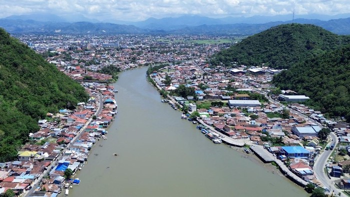 Foto aerial permukiman warga dan terminal kontainer di muara Sungai Bone, Kota Gorontalo, Gorontalo, Senin (13/10/2025). Muara Sungai Bone menjadi salah satu pusat perdagangan tempat dibangunnya Pelabuhan Pendaratan Ikan (PPI), Pelabuhan Gorontalo, terminal kontainer, terminal BBM, objek wisata hingga usaha kuliner warga di daerah tersebut. ANTARA FOTO/Adiwinata Solihin